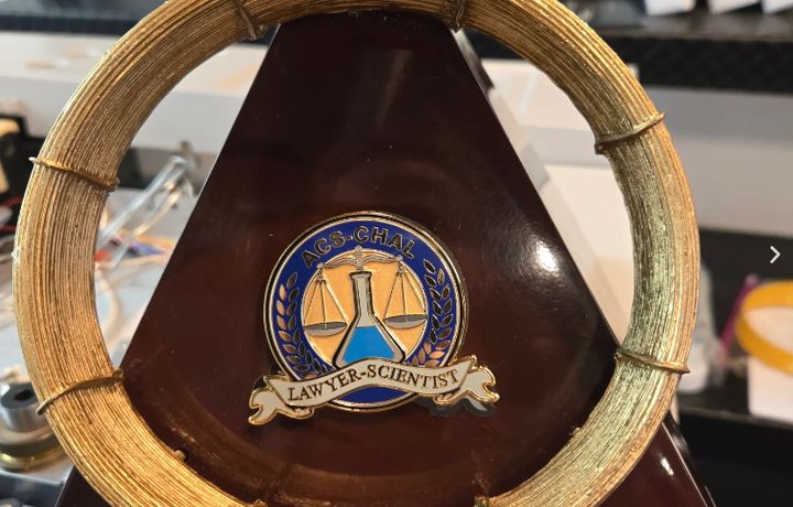 The Golden Column award, an ACS-CHAL Lawyer-Scientist medallion mounted inside a coiled gold chromatography column