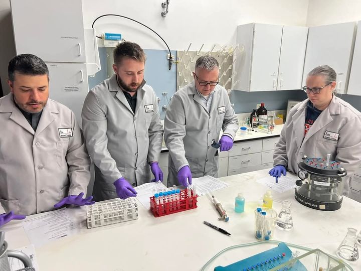 Group of attorneys in Axion lab coats working with test-tube racks during a forensic analysis workshop
